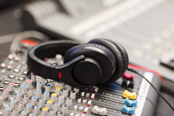Closeup of headphones on Sound Mixer In Professional Radio Studio